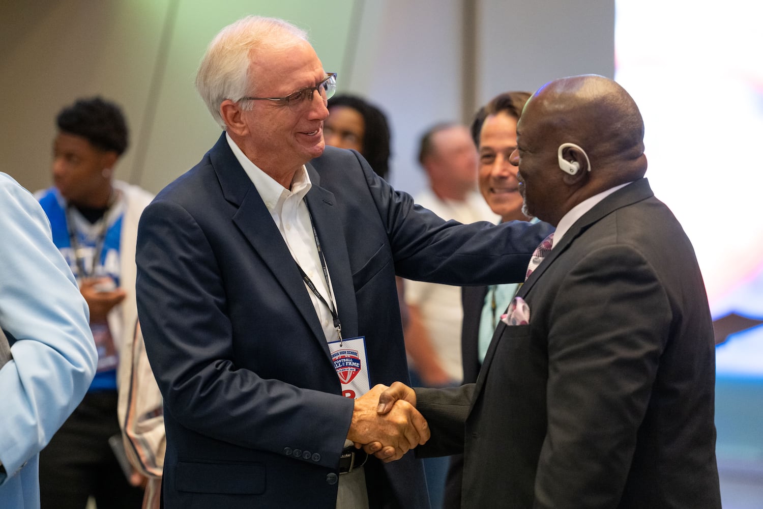 David Carpenter (left) greets Randy Mitchell, both members 1976 Warner Robbins championship football team, while attending the Georgia High School Football Hall of Fame induction ceremony Saturday, Oct. 25, 2025, at the College Football Hall of Fame in Atlanta. (Daniel Varnado for the AJC)