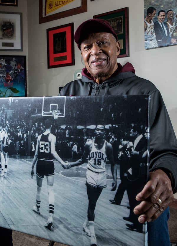 Jerry Harkness, former Loyola Ramblers basketball star, holds a picture from a March 15, 1963, game against Mississippi State. He was team captain for the 1963 Loyola NCAA tournament championship team. (Zbigniew Bzdak/Chicago Tribune/TNS)