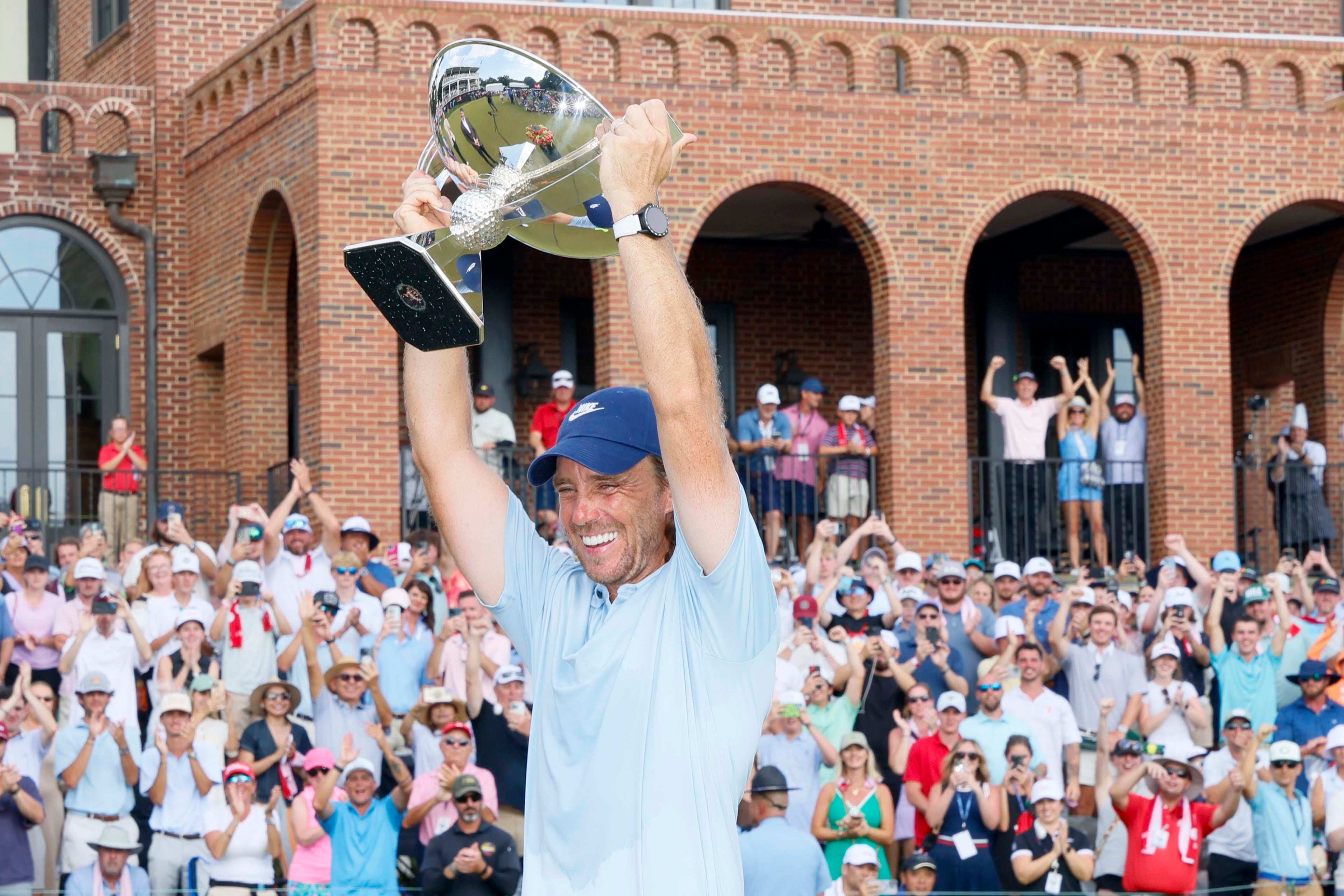 Tommy Fleetwood of England smiles as he lifts the PGA Tour Championship trophy at East Lake Golf Club on Sunday, Aug. 24, 2025, in Atlanta. (Miguel Martinez/ AJC)