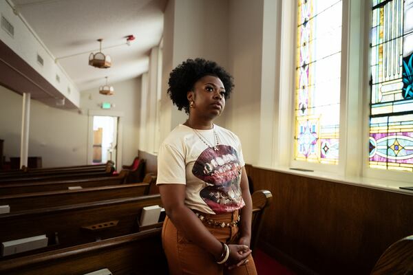 Amyna Price, Birmingham resident and daughter of the current pastor at 16th Street Baptist Church, stands in the sanctuary of this historic church. (Bob Miller for the AJC)