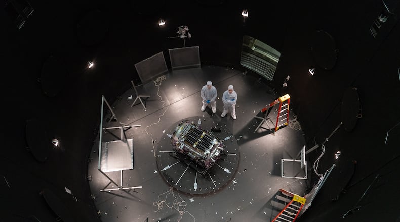FILE - This photo provided by NASA shows Kieran Wilson, LINK's principal investigator, and Hunter Robertson, a space systems engineer, both at Katalyst Space, standing next to their spacecraft inside the SES (Space Environment Simulator) at NASA's Goddard Space Flight Center in Greenbelt, Md., April 17, 2026, ahead of thermal vacuum testing. (Sophia Roberts/NASA via AP, File)