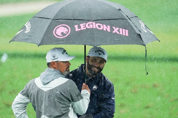 Jon Rahm, of Spain, waits in the rain on the driving range before a practice round for the PGA Championship golf tournament at the Quail Hollow Club, Monday, May 12, 2025, in Charlotte, N.C. (AP Photo/Matt York)