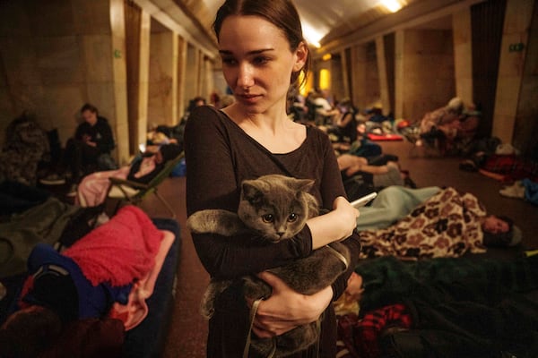 Maria, 25, holds a cat on the platform of a metro station as they take cover during a Russian attack on Kyiv, Ukraine, on Thursday, July 10, 2025. (AP Photo/Evgeniy Maloletka)