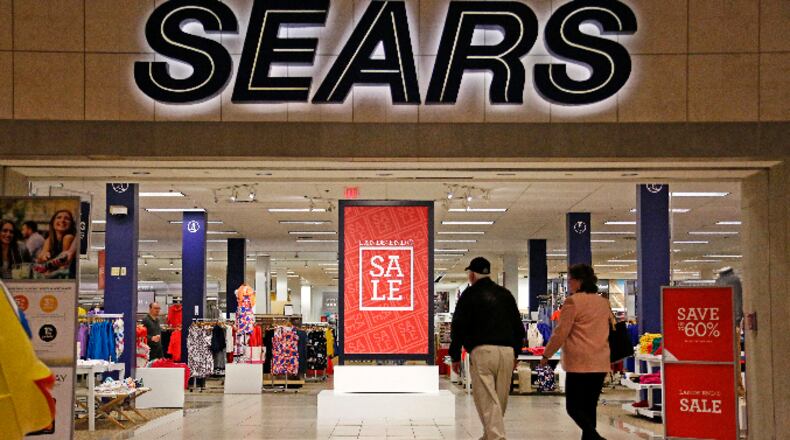 FILE - In this Wednesday, Feb. 8, 2017, file photo, shoppers walk into a Sears store in Pittsburgh. Sears Holdings Corp. on Thursday, March 9, 2017, reported a loss of $607 million in its fiscal fourth quarter. (AP Photo/Gene J. Puskar, File)