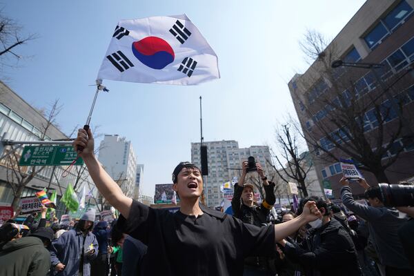 People react after hearing the news that President Yoon Suk Yeol was removed from office, in Seoul, South Korea, Friday, April 4, 2025. (AP Photo/Lee Jin-man)