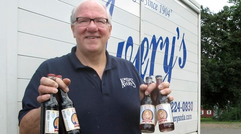 Rob Metz, general manager of Avery's Beverages, holds samples of the company's latest specialty sodas, Hillary Hooch and Trump Tonic, outside the Avery's bottling facility, Monday, July 11, 2016, in New Britain, Conn. This is the third presidential race that company created candidate-based sodas and held a straw poll based on sales. During the last two cycles, Barack O'Berry beat John McCream and Cream de Mitt. (AP Photo/Pat Eaton-Robb)