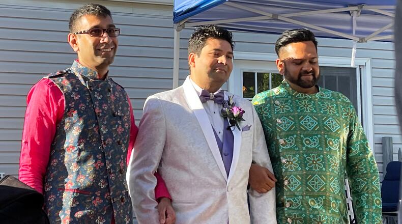 This photo provided by Jolene Gosha shows Venus Patel, left, walking his friend, Pratik Jhaveri, center, down the wedding aisle in Collinsville, Ill., June 18, 2022. CORRECTION: Corrects Jolene's surname from Gosh to Gosha. (Jolene Gosha via AP)
