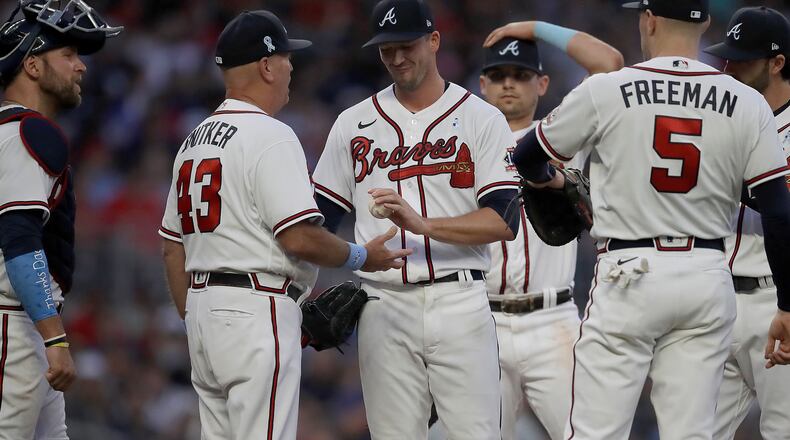 Braves pitcher Drew Smyly (center) hands the ball to manager Brian Snitker (43) in the sixth inning of the second game of a doubleheader against the St. Louis Cardinals, Sunday, June 20, 2021, at Truist Park in Atlanta. (Ben Margot/AP)