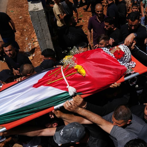 Mourners carry the body of Palestinian Zakaria Qatousa, during his funeral in the West Bank town of Deir Qaddis Wednesday, May 13, 2026. (AP Photo/Mahmoud Illean)
