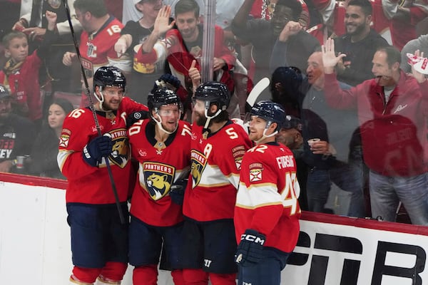 Florida Panthers center Jesper Boqvist (70) celebrates with Aleksander Barkov (16), Aaron Ekblad (5) and Gustav Forsling (42) after scoring a goal against the Carolina Hurricanes during the third period in Game 3 of the NHL hockey Stanley Cup Eastern Conference finals Saturday, May 24, 2025, in Sunrise, Fla. (AP Photo/Lynne Sladky)