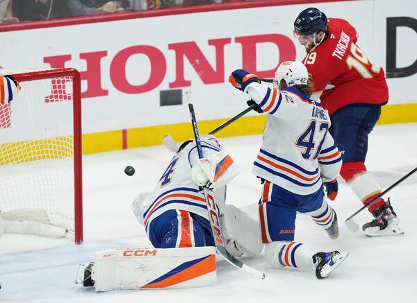 Florida Panthers' Matthew Tkachuk (19) scores against Edmonton Oilers goalie Stuart Skinner, left, as Oilers'. Kasperi Kapanen (42) defends during the first period in Game 4 of the NHL hockey Stanley Cup Final in Sunrise, Fla., Thursday, June 12, 2025. (Nathan Denette/The Canadian Press via AP)