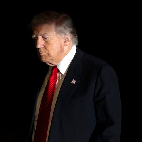 President Donald Trump is illuminated by a camera flash as he walks across the South Lawn of the White House, Sunday, Nov. 2, 2025, in Washington, after returning from a trip to Florida. (AP Photo/Mark Schiefelbein)