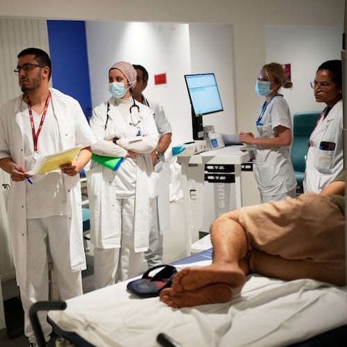 Doctors and nurses take care of a patient at the emergency department of the Paris-Saclay Hospital, outside Paris, Tuesday June 30, 2026. (AP Photo/Christophe Ena )