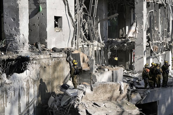 Rescue workers and military personnel inspect the site of a direct hit from an Iranian missile strike in Ramat Gan, Israel, Thursday, June 19, 2025. (AP Photo/Oded Balilty)