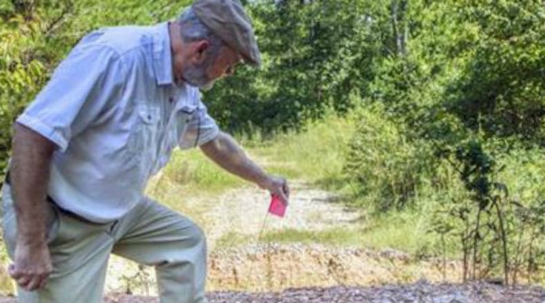 Coker Creek, Tenn., resident and historical preservationist Marvin Harper observes damage to a section of the Trail of Tears in the Appalachian Mountains. The flag indicates a spot where the U.S. Forest Service used heavy equipment to make trenches and berms in what agency officials now say was in violation of federal laws,