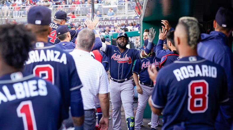 Atlanta Braves designated hitter Marcell Ozuna, center, celebrates after his solo home run during the fourth inning of a baseball game against the Washington Nationals at Nationals Park, Saturday, April 1, 2023, in Washington. (AP Photo/Alex Brandon)