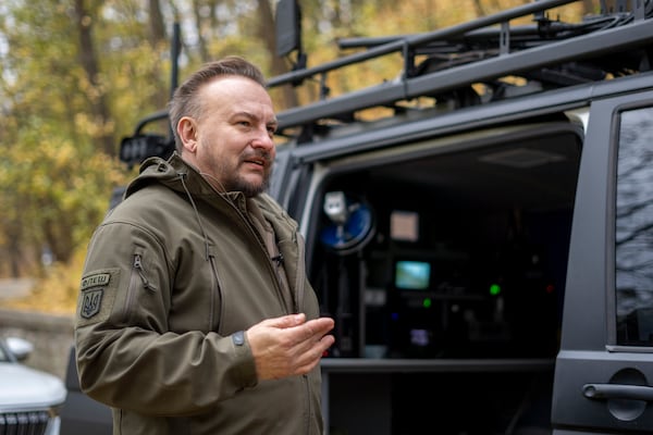 FILE - Serhii Beskrestnov, more widely known as Flash, a Ukrainian electronics expert who hunts drones for the military, stands near his kitted-out black van in Kyiv, Ukraine, Nov. 4, 2024. (AP Photo/Hanna Arhirova, File)