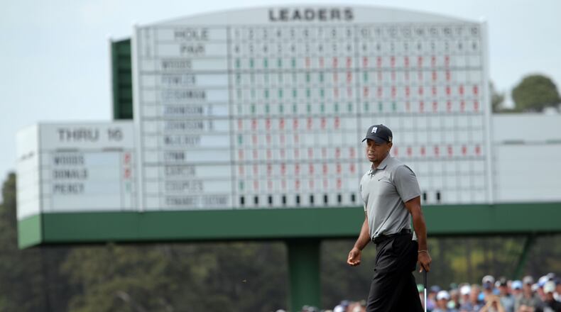 Tiger Woods' smile fades as he reacts to a missed putt on the 17th green.