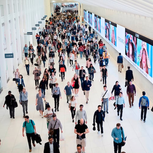 FILE - Commuters walk through a corridor in the World Trade Center Transportation Hub in New York on June 21, 2019. (AP Photo/Mark Lennihan, File)