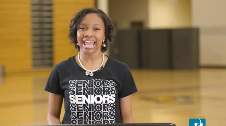A screenshot of Lauren Hester, valedictorian of Coretta Scott King Young Women's Leadership Academy in Atlanta, as she gives a speech in an empty gym during a video celebrating graduation.
