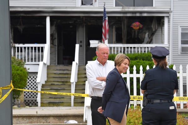 Massachusetts Gov. Maura Healey, center, and Fall River Mayor Paul Coogan, left, speak with a member of law enforcement, right, near the Gabriel House assisted living facility, Monday, July 14, 2025, following a fire that started late Sunday, in Fall River, Mass. (AP Photo/Steven Senne)