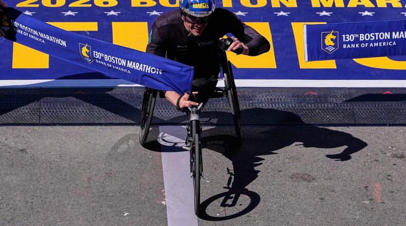 Marcel Hug, of Switzerland, breaks the tape to win the men's wheelchair division at the Boston Marathon, Monday, April 20, 2026, in Boston. (AP Photo/Charles Krupa)