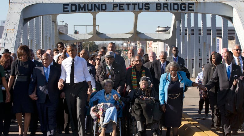FILE - In this March 7, 2015, file photo, singing "We Shall Overcome," President Barack Obama, third from left, walks holding hands with Amelia Boynton, who was beaten during "Bloody Sunday," as they and the first family and others including Rep. John Lewis, D-Ga, left of Obama, walk across the Edmund Pettus Bridge in Selma, Ala., for the 50th anniversary of "Bloody Sunday," a landmark event of the civil rights movement. Some residents in the landmark civil rights city of Selma, Ala., are among the critics of a bid to rename the historic bridge where voting rights marchers were beaten in 1965. (AP Photo/Jacquelyn Martin, File)