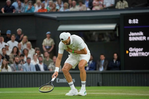 Bulgaria's Grigor Dimitrov clutches his chest with an injury which forced him to retire injured from a fourth round men's singles match against Italy's Jannik Sinner at the Wimbledon Tennis Championships in London, Monday, July 7, 2025. (AP Photo/Kin Cheung)