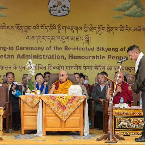 Chief Justice Commissioner of the Tibetan Supreme Justice Commission, Yeshi Wangmo, left, administers the oath of office to Penpa Tsering, right, as the political leader of Tibet's government-in-exile, in the presence of Tibetan spiritual leader the Dalai Lama, center, in Dharamshala, India, Wednesday, May 27, 2026. (AP Photo/ Shailesh Bhatnagar)