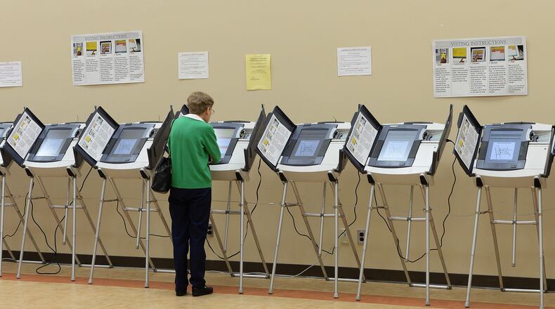 In this 2013 AJC file photo, a voter uses a balloting machine at the North Fulton Service.