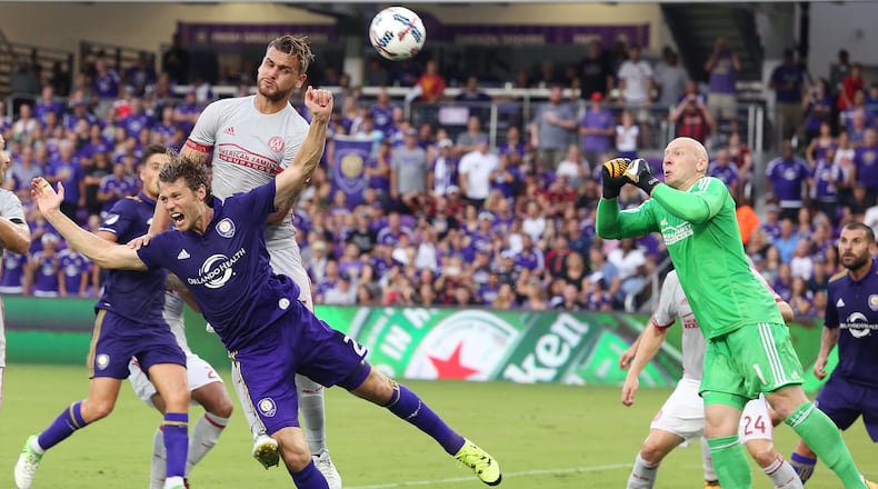 Atlanta United goalkeeper Brad Guzan, right, makes a save on a shot by Orlando City's Jonathan Spector (2) at Orlando City Stadium on Friday, July 21, 2017, in Orlando, Fla. (Stephen M. Dowell/Orlando Sentinel/TNS)