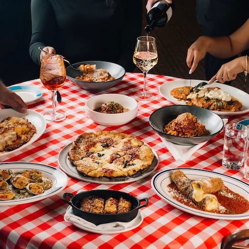 A table full of Italian food on a checkered tablecloth