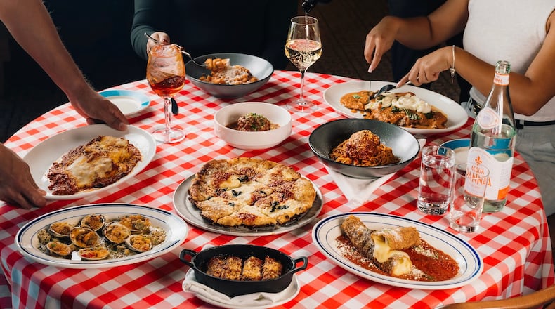 A table full of Italian food on a checkered tablecloth