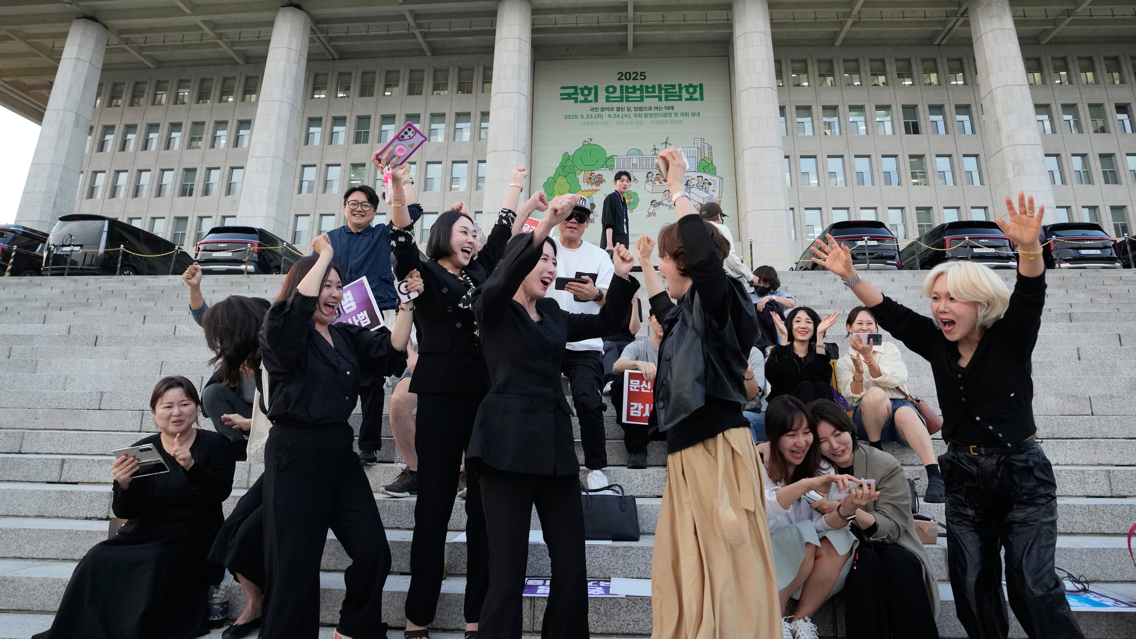 Members of the Korea Tattoo Federation celebrate after hearing the news that parliament passed a bill that would allow non-medical personnel to give tattoos outside the National Assembly, in Seoul, South Korea, Thursday, Sept. 25, 2025. (AP Photo/Ahn Young-joon)