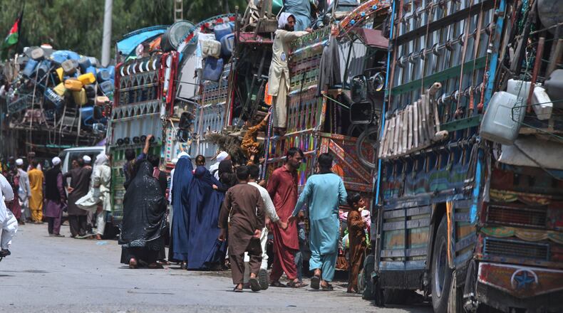 FILE - Afghan refugee families heading back to their homeland, gather next to trucks loaded with their belongings as they wait for documentation at the UNHCR Voluntary Repatriation Centre in Azakhel, Nowshera a district of Pakistan's Khyber Pakhtunkhwa, Monday, Aug. 25, 2025. (AP Photo/Muhammad Sajjad, File)