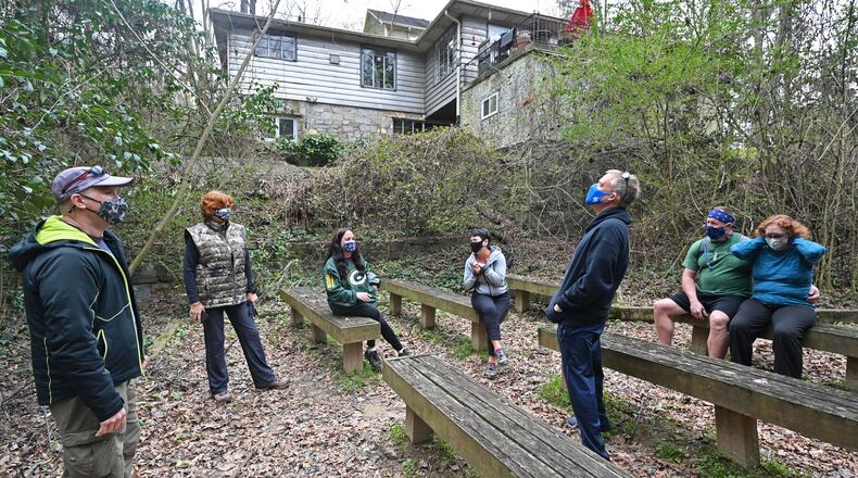 Steve Novotny (left) talks to friends as they take a short break while hiking the Whetstone Trail in Atlanta's Westside earlier this month. They routinely volunteered together at Habitat for Humanity before the pandemic made that impossible. Novotny now organizes hikes as a way to continue socializing in a distanced way. (Hyosub Shin / Hyosub.Shin@ajc.com)