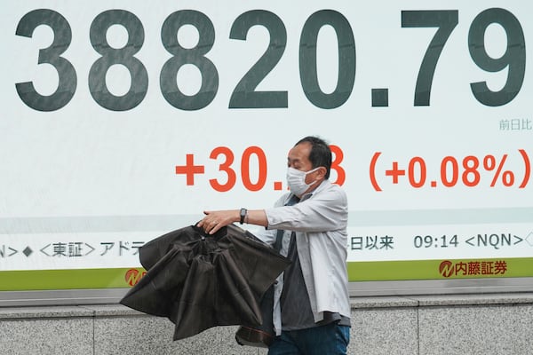 A person walks in front of an electronic stock board showing Japan's Nikkei index at a securities firm Wednesday, June 25, 2025, in Tokyo. (AP Photo/Eugene Hoshiko)