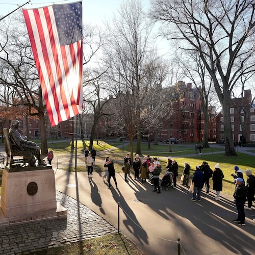 FILE - People take photos near a John Harvard statue, left, on the Harvard University campus, Jan. 2, 2024, in Cambridge, Mass. (AP Photo/Steven Senne, File)