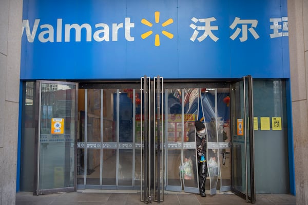 FILE - A customer wears a face mask as she leaves a Walmart grocery store in Beijing, Feb. 1, 2020. (AP Photo/Mark Schiefelbein, File)