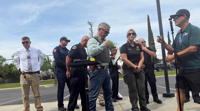 Tulare County Sheriff Mike Boudreaux, center, attends a news conference after a sheriff's deputy was shot and killed Thursday, April 9, 2026, in Porterville, Calif. (Tulare County Sheriff's Office via AP)