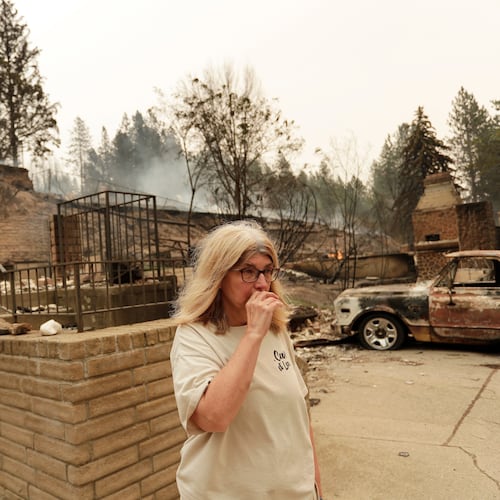 Kimberley Sather stands at the duplex she rents on W. Indian Trail Rd. after it burned in a wildfire in Spokane, Wash., Sunday, Aug. 2, 2026. (AP Photo/Young Kwak)