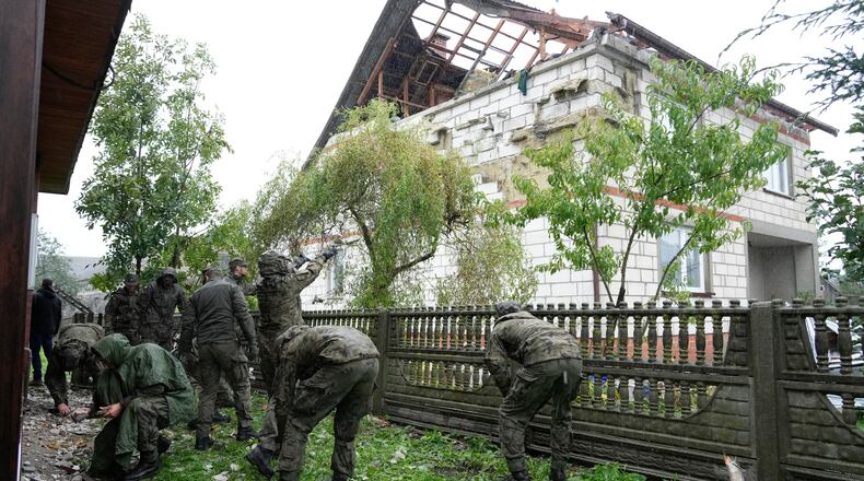 FILE - Territorial defense officers clean up debris from the destroyed roof of a house in Wyryki near Lublin, Poland, after Russian drones violated Polish airspace during an attack on Ukraine, on Sept. 11, 2025. (AP Photo/Czarek Sokolowski, File)