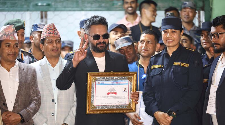 Balendra Shah, foreground, former mayor of Kathmandu Metropolitan City and prime ministerial candidate of the Rastriya Swatantra Party, receives his victory certificate after defeating former Prime Minister Khadga Prasad Oli of the Communist Party of Nepal–Unified Marxist-Leninist (CPN-UML) in Jhapa, about 267 miles (430 kilometers) southeast of Kathmandu, Nepal, Sunday, March 8, 2026. (AP Photo/Umesh Karki)
