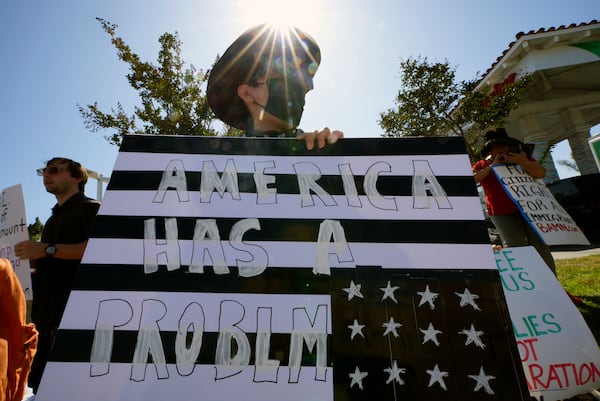 Protesters hold signs and chant slogans during a protest against the Trump Administration's immigration policies in Paramount, Calif. on Tuesday, June 17, 2025. (AP Photo/Damian Dovarganes)