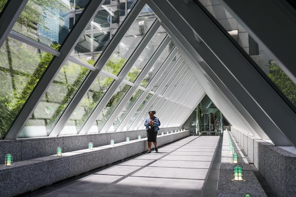 A pedestrian walks through a John Portman skybridge in Atlanta. The web of bridges is part of Atlanta’s identity. (Abbey Cutrer/AJC)