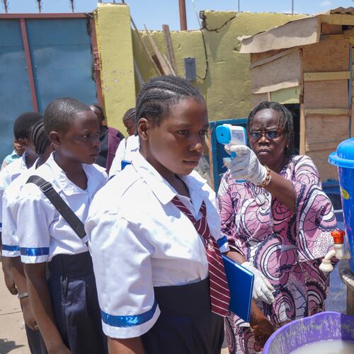 A school official checks students' temperatures as they enter school, on the first day of the new school year amid the Ebola virus outbreak, in Ituri, Congo, Tuesday, Sept.1, 2026. (AP Photo/Dieudonne Dirole)