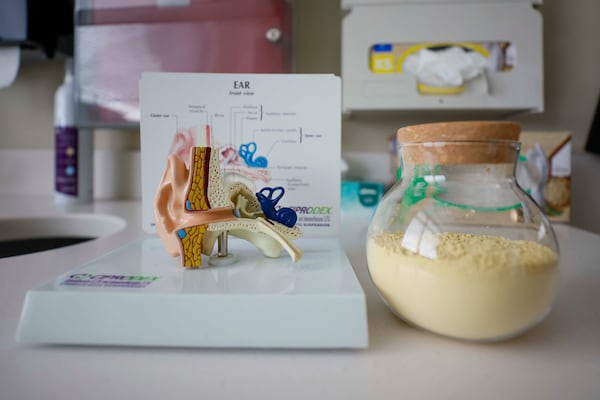 A model of an ear and a jar of pollen are displayed in a medical room at Wellstar Vinings Health Park on Monday, March 9, 2025. Medical experts describe what pollen looks like as pollen season approaches. (Miguel Martinez/AJC)