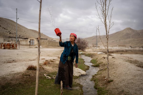 Tashi Angmo, 41, performs her morning prayers with water before collecting it for daily use at the newly relocated settlement of the abandoned Samjung village in the Mustang region, 462 kilometers (288 miles) west of Kathmandu, Nepal, Saturday, April 19, 2025. (AP Photo/Niranjan Shrestha)