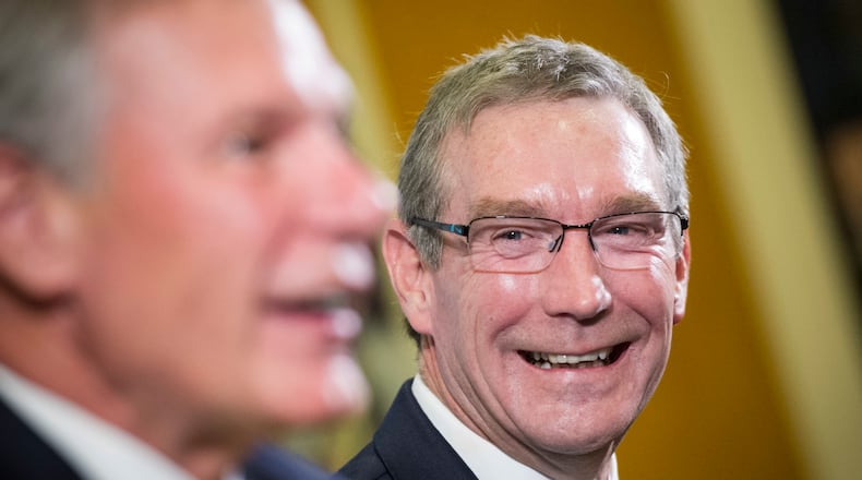 Todd Stansbury, right, listens to Georgia Tech President Bud Peterson speak during a news conference in which he is introduced Stansbury as the new athletic director at the school, Thursday, Sept. 22, 2016, in Atlanta. Stansbury had served as Oregon State's athletic director since June 2015 and is a former Georgia Tech football player and 1984 alumnus. (AP Photo/John Amis)