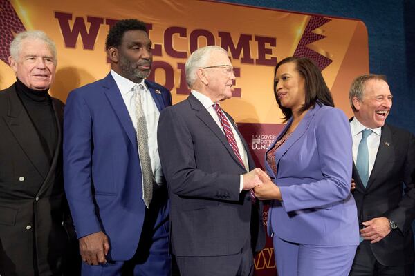 Hall of Fame running back John Riggins, from left, former Washington Commanders quarterback Doug Williams and former coach Joe Gibbs greet District of Columbia Mayor Muriel Bowser, next to Washington Commanders controlling owner Josh Harris, after an announcement that a new home for the NFL football team will be built on the site of the old RFK Stadium, Monday, April 28, 2025, at the National Press Club in Washington. (AP Photo/Jacquelyn Martin)